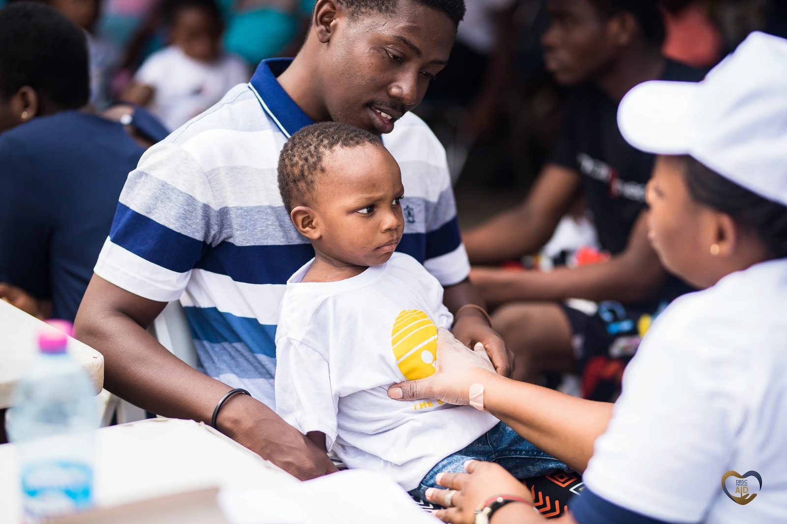 A DBSC Medical Aid volunteer caring for a child at a community screening